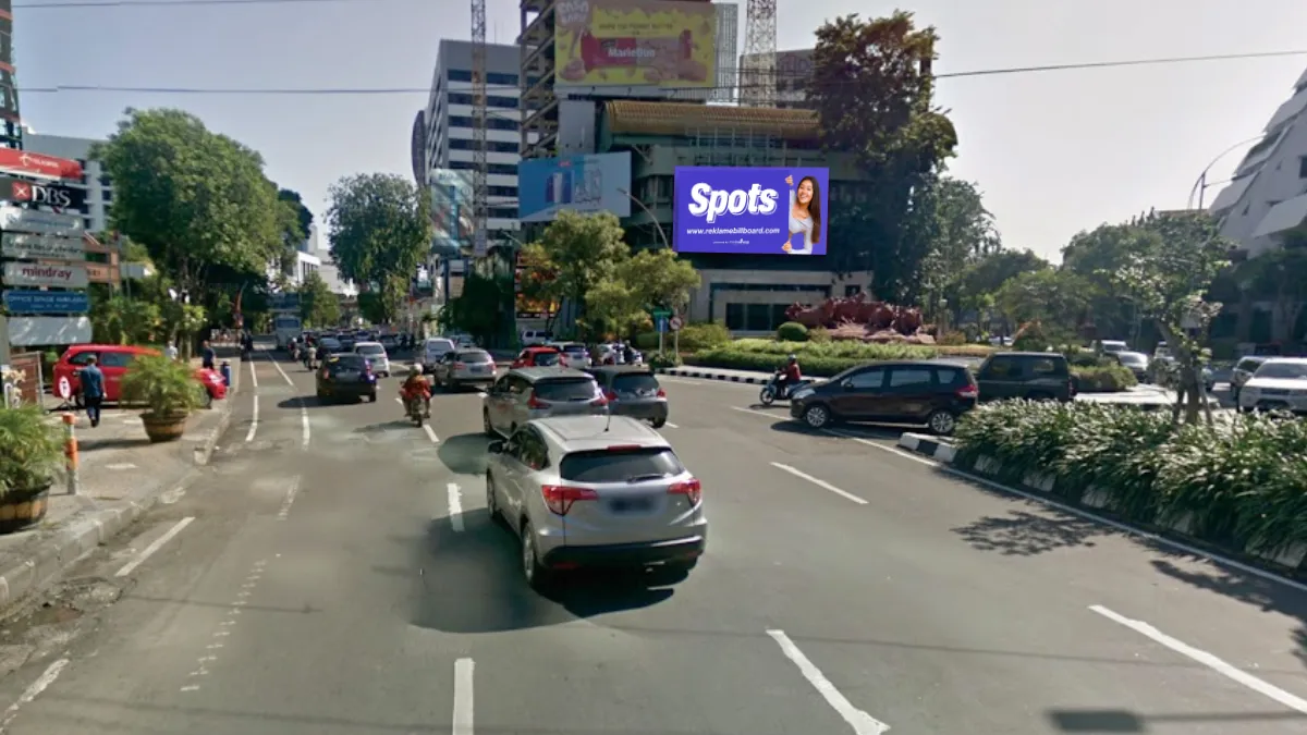 Sewa Billboard Spots di Jalan Basuki Rahmat, Surabaya dengan tampilan iklan outdoor perempuan menunjuk logo Spots