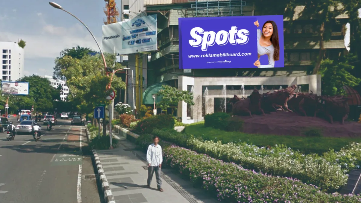 Sewa Billboard Spots di Jalan Basuki Rahmat, Surabaya dengan tampilan iklan outdoor perempuan menunjuk logo Spots